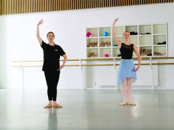 A ballet dancer and a teacher doing port de bras at the centre