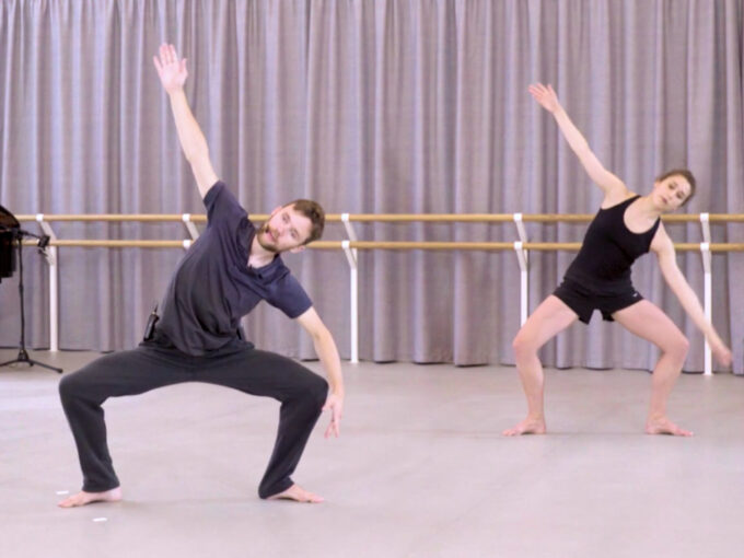 A contemporary dance teacher and a demonstrator are in plie at the centre.